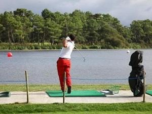 スーストンにあるVilla Soustons, 2 pièces, 4 personnes - FR-1-379-72の女が湖畔でゴルフをしている