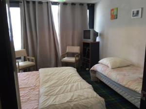 a bedroom with two beds and a tv in it at Appartement La Mongie, 2 pièces, 7 personnes - FR-1-404-160 in La Mongie