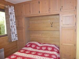 a small bed in a room with wooden cabinets at Appartement Méribel, 3 pièces, 6 personnes - FR-1-411-185 in Les Allues