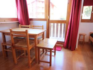 a dining room with a table and chairs and windows at Studio Peisey-Vallandry, 1 pièce, 4 personnes - FR-1-411-75 in Landry