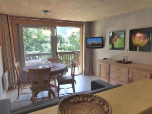 a living room with a table and a balcony at Charmant appartement 3 pièces à Méribel, au pied des pistes, avec terrasse exposée sud et proche du centre - FR-1-411-77 in Les Allues