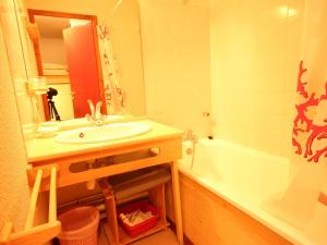 La salle de bains est pourvue d'un lavabo, d'un miroir et d'une baignoire. dans l'établissement Appartement Peisey-Vallandry, 1 pièce, 4 personnes - FR-1-411-285, à Landry