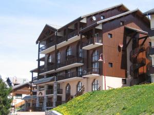 un grand bâtiment avec balcon sur une colline dans l'établissement Appartement Peisey-Vallandry, 1 pièce, 4 personnes - FR-1-411-285, à Landry