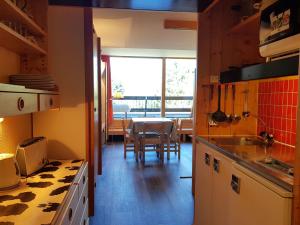 a kitchen with a table and a dining room at Studio 4 pers. à Arc 1600 près des pistes avec balcon et WiFi - FR-1-411-303 in Arc 1600