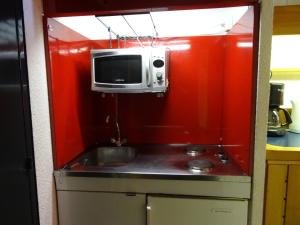 a small kitchen with a sink and a microwave at Studio 4 personnes Arc 1600 à 50m des pistes, balcon, TV - FR-1-411-335 in Arc 1600