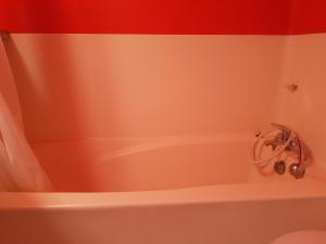 a white bath tub in a bathroom with red walls at Studio Les Arcs 2000, 1 pièce, 5 personnes - FR-1-411-350 in Arc 2000