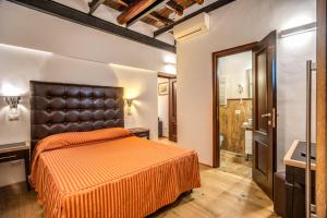 1 Schlafzimmer mit einem orangenen Bett und einem Badezimmer in der Unterkunft Casa Leonetto in Rom