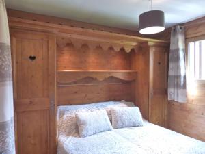 um quarto com uma cama e uma cabeceira em madeira em Appartement Méribel, 3 pièces, 6 personnes - FR-1-411-406 em Les Allues