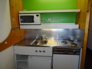 een kleine keuken met een wastafel en een magnetron bij Studio Les Arcs 1800, 1 pièce, 5 personnes - FR-1-411-284 in Arc 1800