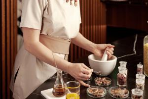 una mujer preparando comida en un tazón en un mostrador en Hotel Grand Kopaonik, en Kopaonik