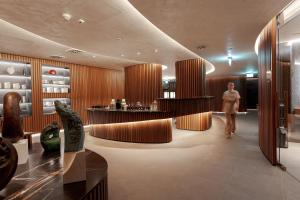 Eine Frau geht durch eine Lobby mit einer Bar in der Unterkunft Hotel Grand Kopaonik in Kopaonik