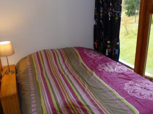 uma cama com um cobertor ao lado de uma janela em Appartement Les Arcs 1800, 2 pièces, 6 personnes - FR-1-411-338 em Arc 1800