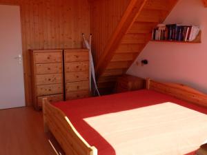 een slaapkamer met een houten bed en een rode deken bij Appartement Les Arcs 1800, 4 pièces, 9 personnes - FR-1-411-339 in Arc 1800