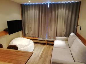 uma sala de estar com um sofá branco e uma grande janela em Appartement Les Arcs 1800, 2 pièces, 6 personnes - FR-1-411-338 em Arc 1800