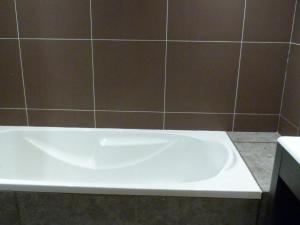een wit bad in een badkamer met een tegelwand bij Appartement Les Arcs 1800, 4 pièces, 9 personnes - FR-1-411-339 in Arc 1800