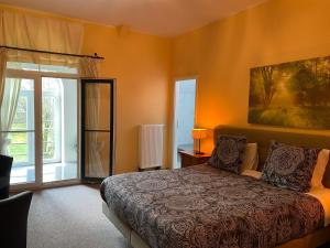 een slaapkamer met een bed en een groot raam bij Château Les Tourelles in Bertrix