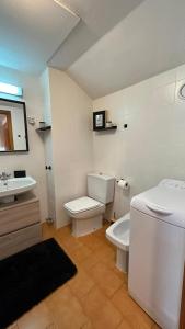 a white bathroom with a toilet and a sink at Estudio a pie de Pistas Baqueira in Baqueira-Beret