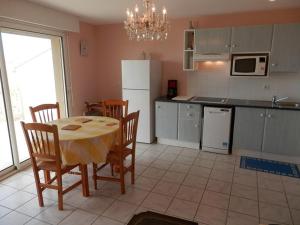 a kitchen with a table and chairs and a refrigerator at Appartement Vieux-Boucau-les-Bains, 3 pièces, 4 personnes - FR-1-379-80 in Vieux-Boucau-les-Bains