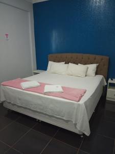 a bedroom with a large bed with two towels on it at Topazzo Hotel in Uruara