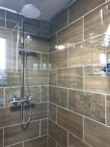a bathroom with a shower with brown tiles at Spacious City Home with Free Parking, Fast Wi-Fi & Netflix in Coventry