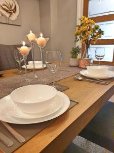 a wooden table with plates and wine glasses on it at Spacious City Home with Free Parking, Fast Wi-Fi & Netflix in Coventry