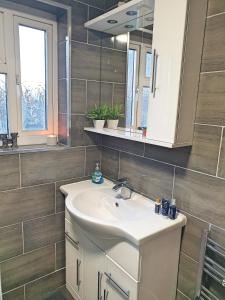 a bathroom with a sink and a mirror at Spacious City Home with Free Parking, Fast Wi-Fi & Netflix in Coventry