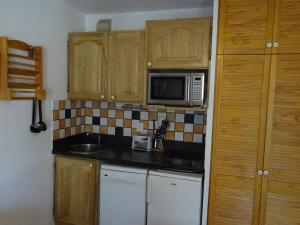 a small kitchen with a sink and a microwave at Appartement Bourg-Saint-Maurice, 2 pièces, 4 personnes - FR-1-411-520 in Bourg-Saint-Maurice