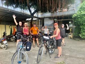 eine Gruppe von Menschen, die neben ihren Fahrrädern stehen in der Unterkunft Thien Phuc Hotel in Ba Tri