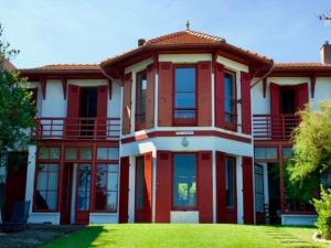 アルカションにあるVilla Arcachon, 11 pièces, 15 personnes - FR-1-433-17の緑の芝生のある大きな赤と白の家