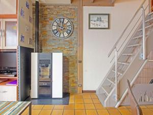 a kitchen with a clock on a brick wall at Chalet cosy avec garage et vues, 3 niveaux, 6 pers, proche Luz, animaux admis - FR-1-402-54 in Viella +2 photos