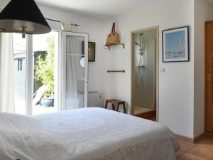 a bedroom with a large white bed and a window at Maison Les Portes-en-Ré, 4 pièces, 6 personnes - FR-1-434-10 in Les Portes