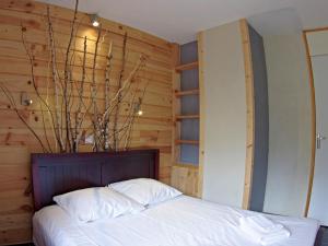 a bedroom with a bed with a wooden wall at Appartement Valmorel, 3 pièces, 4 personnes - FR-1-291-821 in Valmorel
