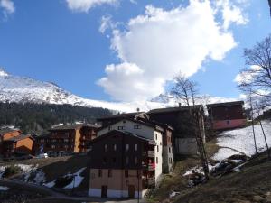 a group of buildings on a hill with a snow covered mountain at Appartement Valmorel, 3 pièces, 4 personnes - FR-1-291-821 in Valmorel