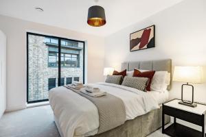 a bedroom with a large bed and a large window at Tailored Stays - Central Cambridge, Lacon House in Cambridge