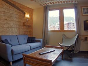 a living room with a couch and a table at Appartement Valmorel, 3 pièces, 4 personnes - FR-1-291-821 in Valmorel
