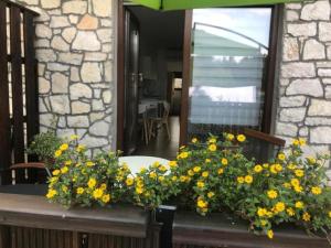 Un mazzo di fiori gialli su un bancone di fronte a uno specchio di Guesthouse Family Bosnic a Laghi di Plitvice