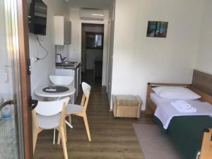 a bedroom with a bed and a table and a sink at Guesthouse Family Bosnic in Plitvička Jezera