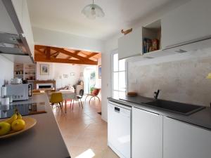 a kitchen with white cabinets and a counter top at Maison à Ars-en-Ré près du port, terrasse ombragée, WiFi, ménage inclus - FR-1-434-8 in Ars-en-Ré +9 photos