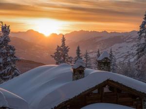 a cabin covered in snow with the sunset in the background at Studio Montvalezan-La Rosière, 1 pièce, 4 personnes - FR-1-398-570 in La Rosière