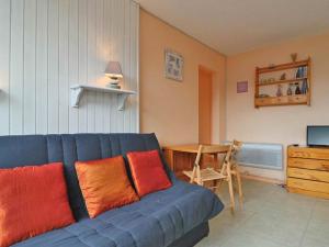 a blue couch with red and orange pillows in a living room at Studio Montvalezan-La Rosière, 1 pièce, 4 personnes - FR-1-398-573 in Montvalezan