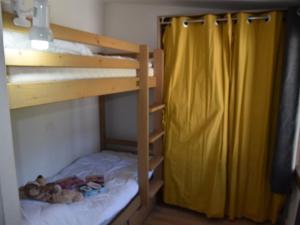 a bedroom with two bunk beds with a yellow curtain at Appartement Montgenèvre, 2 pièces, 4 personnes - FR-1-266-131 in Montgenèvre