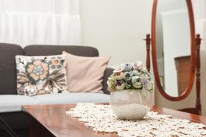 a vase with flowers sitting on a coffee table at Apartman Woolf in Senta