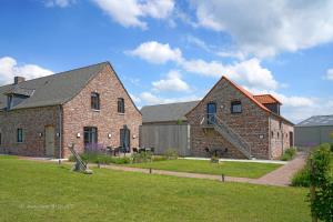 a large brick house with a grass yard at A Coque'Line in Frasnes-lez-Anvaing