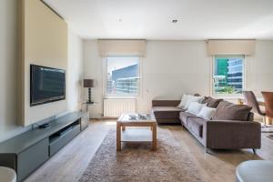 een woonkamer met een bank en een tv bij Rent Top Apartments Avenida Diagonal in Barcelona