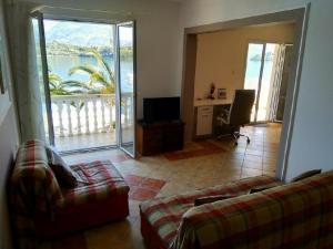 uma sala de estar com 2 sofás e uma varanda em Monténégro dans un site exceptionnel loue des hébergements supérieurs face mer avec plage privée em Tivat
