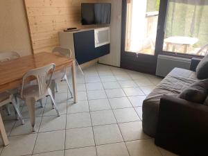 a living room with a table and a couch at Studio La Clusaz, 1 pièce, 4 personnes - FR-1-459-64 in La Clusaz