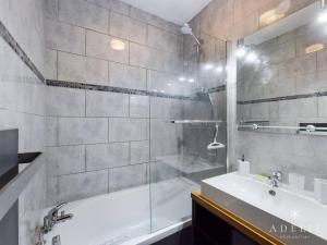 uma casa de banho com um chuveiro, uma banheira e um lavatório. em Appartement Montvalezan-La Rosière, 3 pièces, 6 personnes - FR-1-398-519 em La Rosière