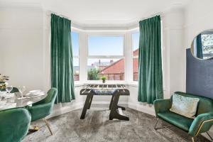 un soggiorno con sedie verdi, tavolo e finestra di Stylish 4 Bed House in Yorkshire - Football Table a Pontefract