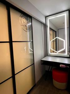 a bathroom with a mirror and a door with a stool at The RED in Kuala Lumpur