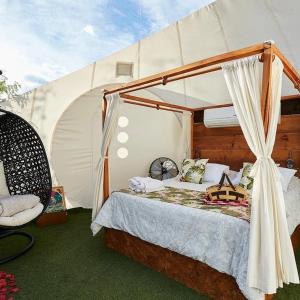 una camera con letto a baldacchino in una tenda. di BubbleSky Glamping 40 min from Medellin a El Retiro